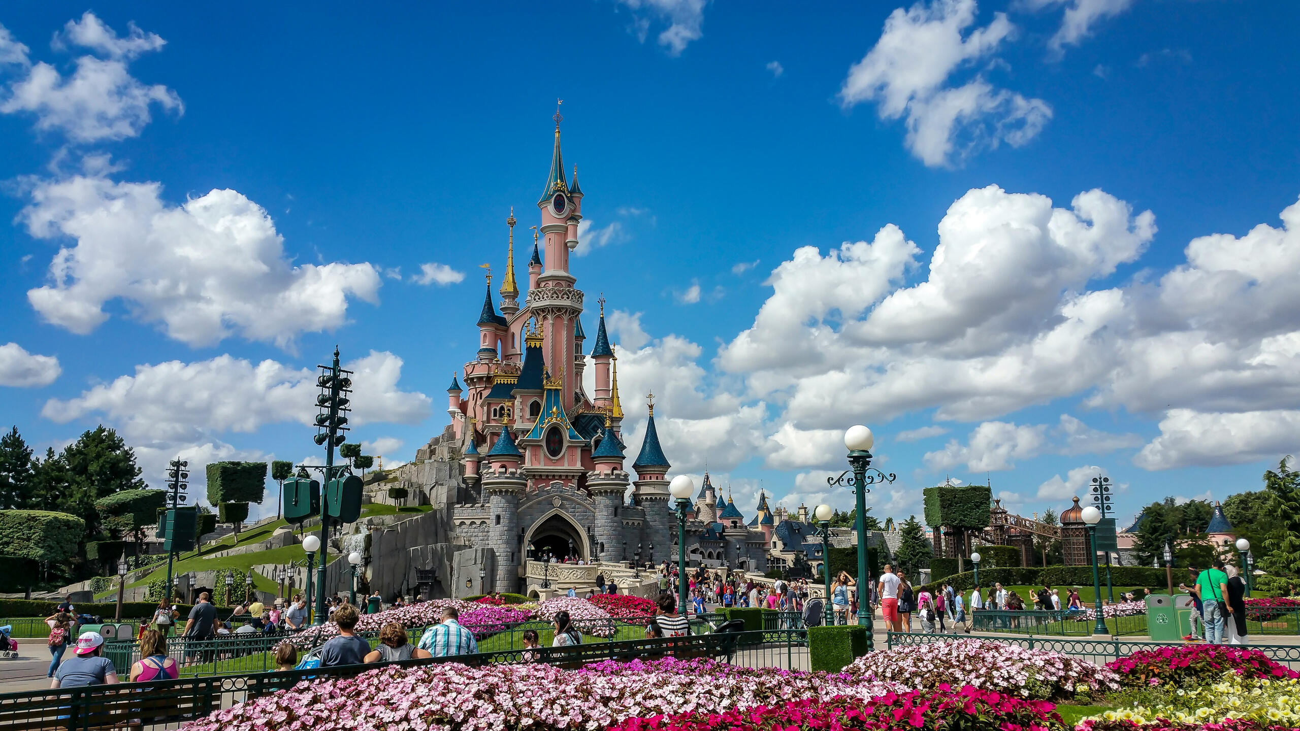 A panoramic view of Disneyland Paris showcasing iconic attractions and vibrant crowds enjoying the magical atmosphere.